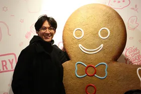 Alex smiling next to a giant gingerbread man